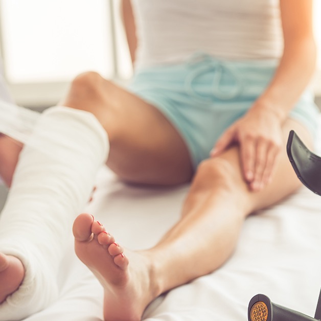 Person with a leg cast seated beside crutches