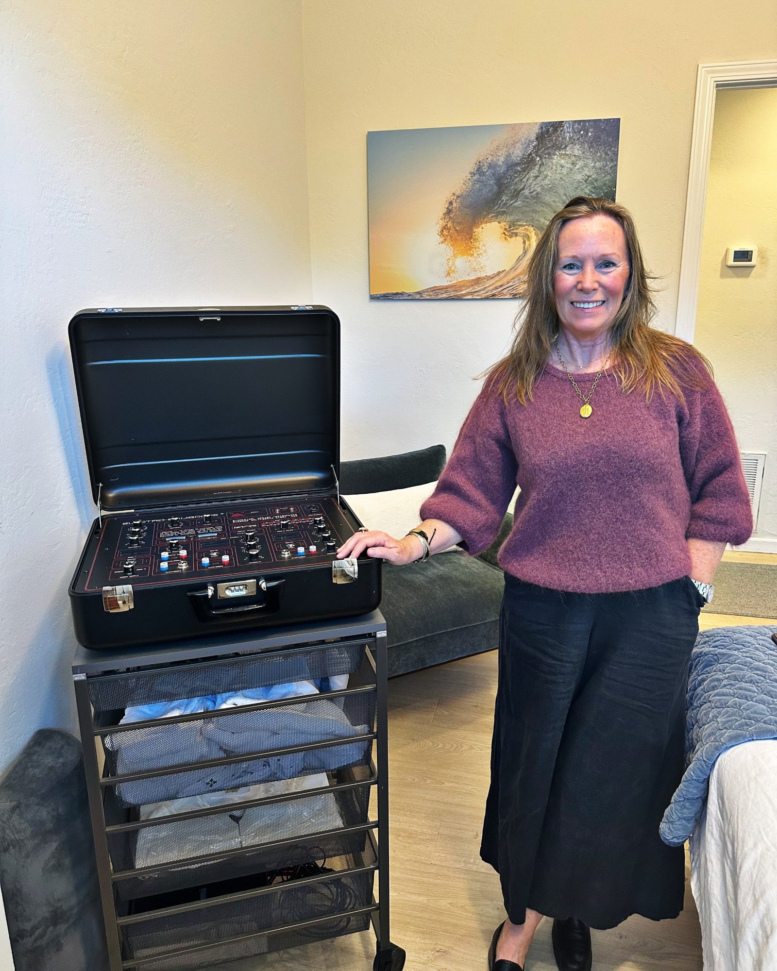 Shannon Gotham smiling beside the Electro-Equiscope in her Mill Valley treatment room